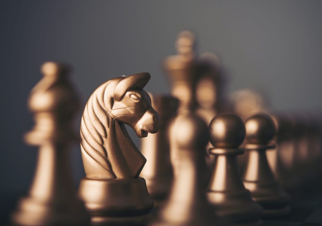 Gold chess pieces on a chessboard.